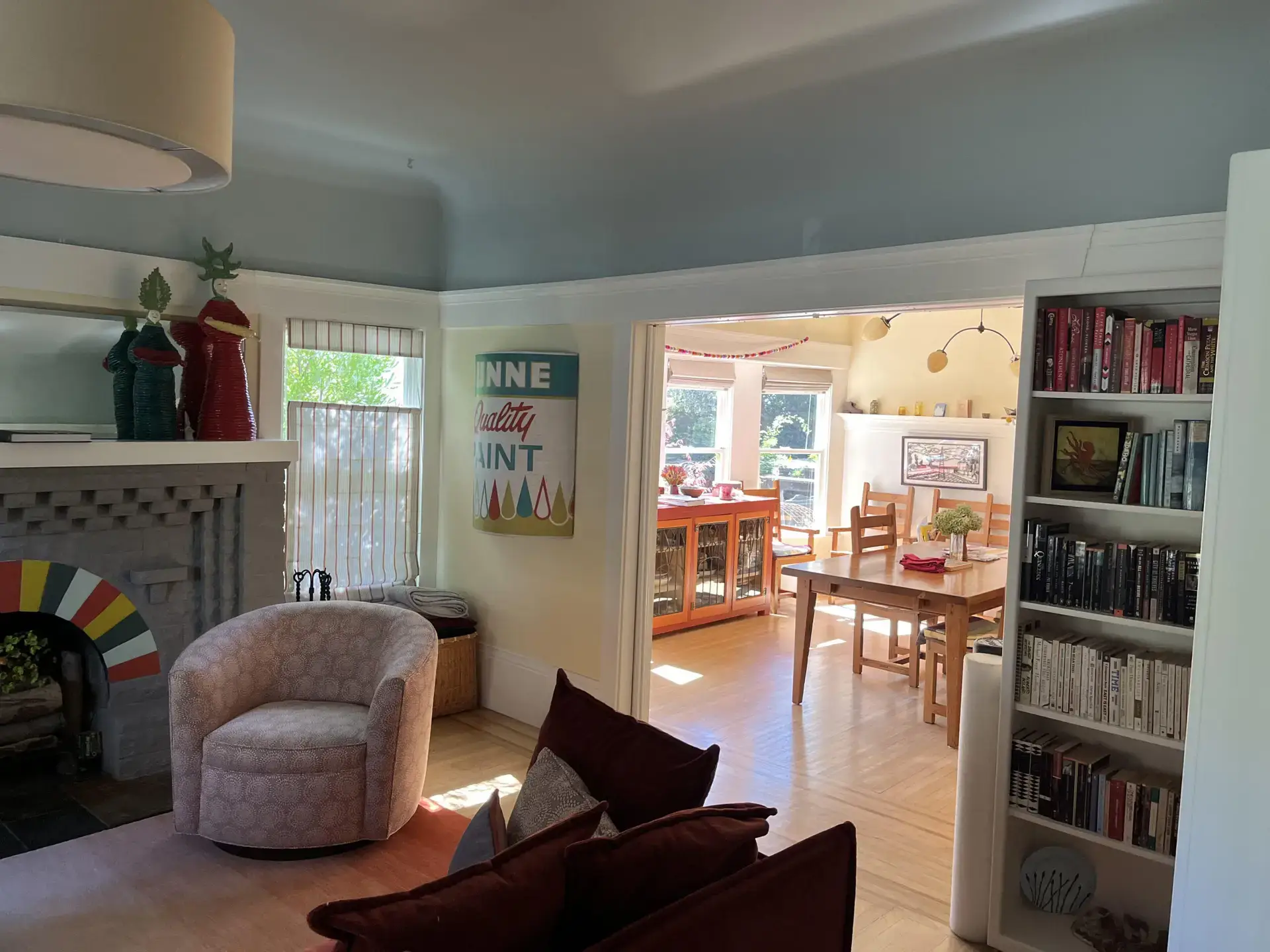Living room with a soft blue coved ceiling, white trim, and a view into the dining room by Integrity Paint and General Contracting
